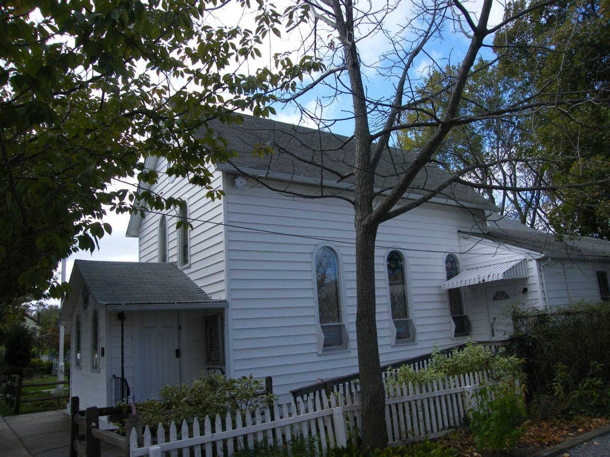 Commons file captioned 'Tifferth-israel Synagogue National Registry' and used as the infobox photo on the Wikipedia article for this Greenport congregation; a Star of David is visible in the stained-glass window in frame.