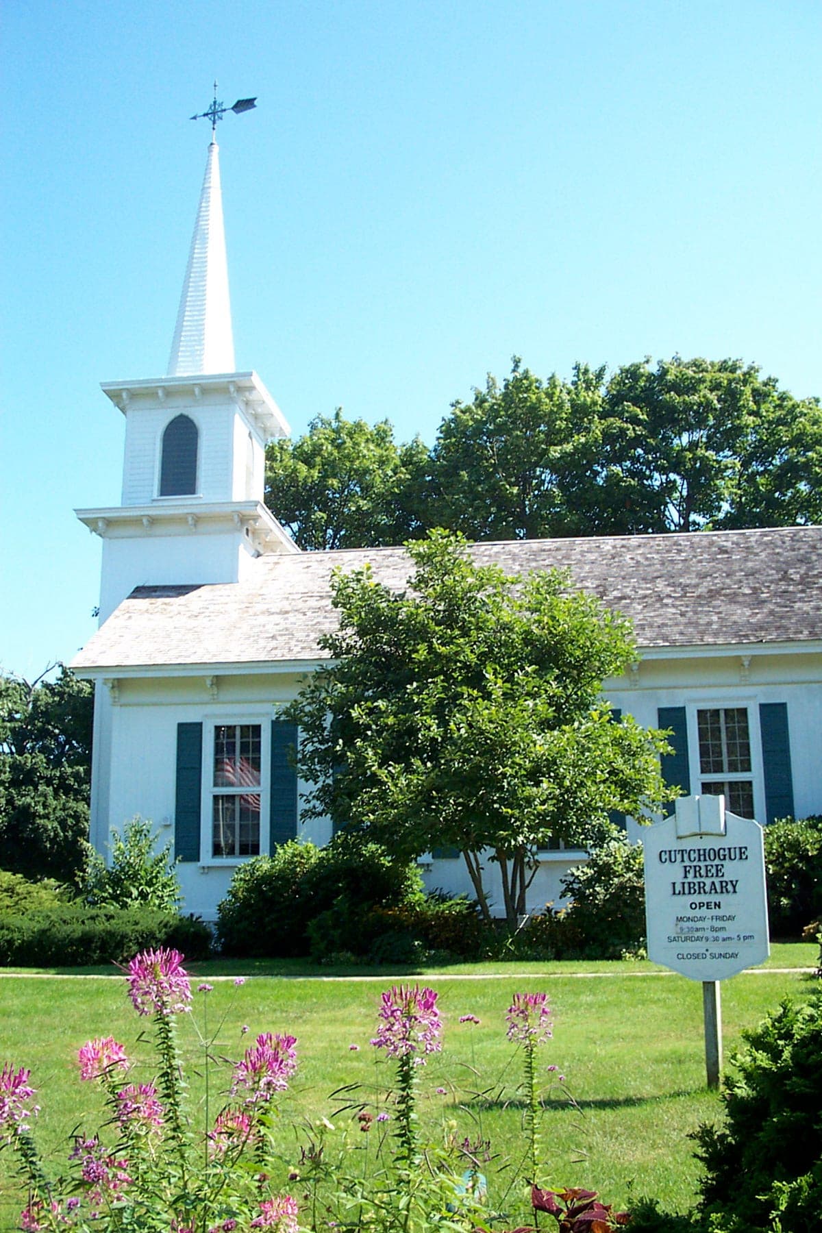 The building's own "CUTCHOGUE FREE LIBRARY" lawn sign stands in the frame, and Wikipedia's Cutchogue article confirms the building itself — a steepled former church — as the library's home ("originally a church built by the Independent Congregational Church and Society in 1862"). The photo's embedded GPS tag (41.0107, -72.4852) sits ~500m from this record's coordinates, consistent with a phone's coarse location fix rather than a different building.